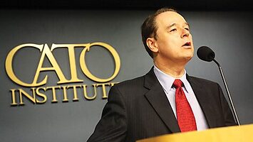 David Boaz stands behind a lectern, with the Cato Institute logo on the wall behind him.