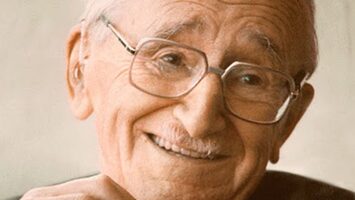 A photographic portrait of a smiling, elderly F.A. Hayek.