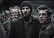 Chris Evans is center screen, dressed in dark, ripped clothing, surrounded by co-stars Jamie Bell and John Hurt in a still frame from the movie Snowpiercer.