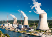 Three nuclear power plant 'cooling stacks' billowing steam are pictured next to a river. 
