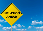 A yellow road sign against a blue sky reads "Inflation Ahead."