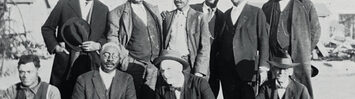 Members of the Colored Citizens Relief Committee and East End Welfare Board pose for a photo following the 1921 Tulsa Race Massacre. The individuals standing include the following (left to right): Williams, Phillips, Esta "Essie" A. Loupe, Reverend E. N. Bryant, Horace T. Hughes, and McLean. The men kneeling include the following (left to right): Perry R. Russell, Ottaway W. Gurley, Bush, and Tucker Gilmer.