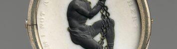 A medallion with the image of a kneeling, chained black man with clasped hands surrounded by the words "Am I not a man and a brother?"