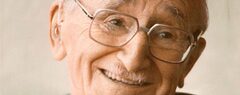 A photographic portrait of a smiling, elderly F.A. Hayek.